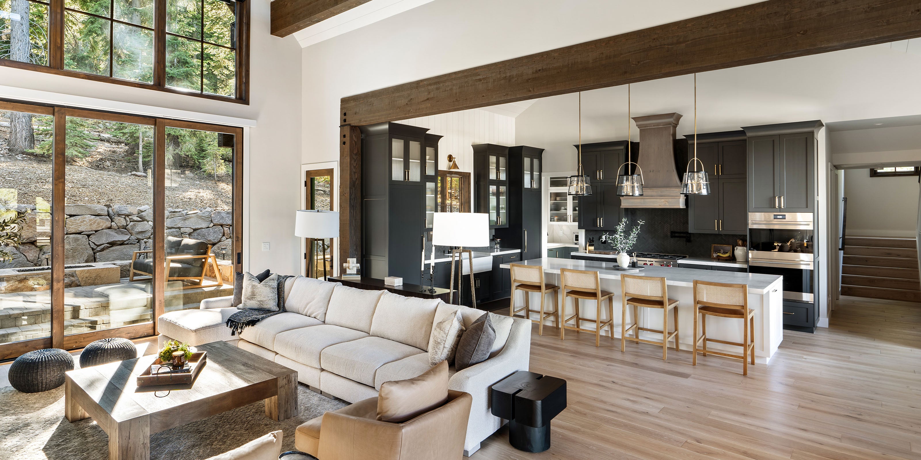 Lake Tahoe home with a modern living room with a view of a kitchen and outdoor area.