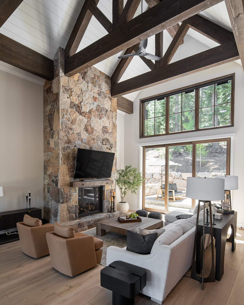 Mountain modern living room in Truckee with stone fireplace, large windows, and wooden beams.